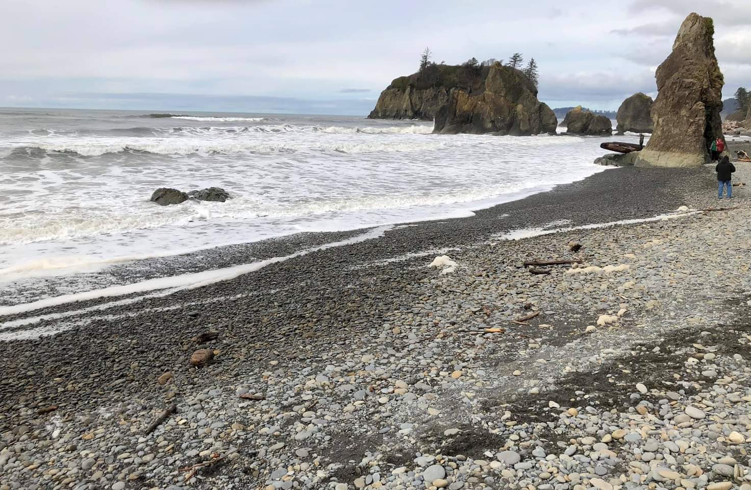 Ruby Beach, pebble shore with white foamy waves lapping the shore and light blue sky at dusk