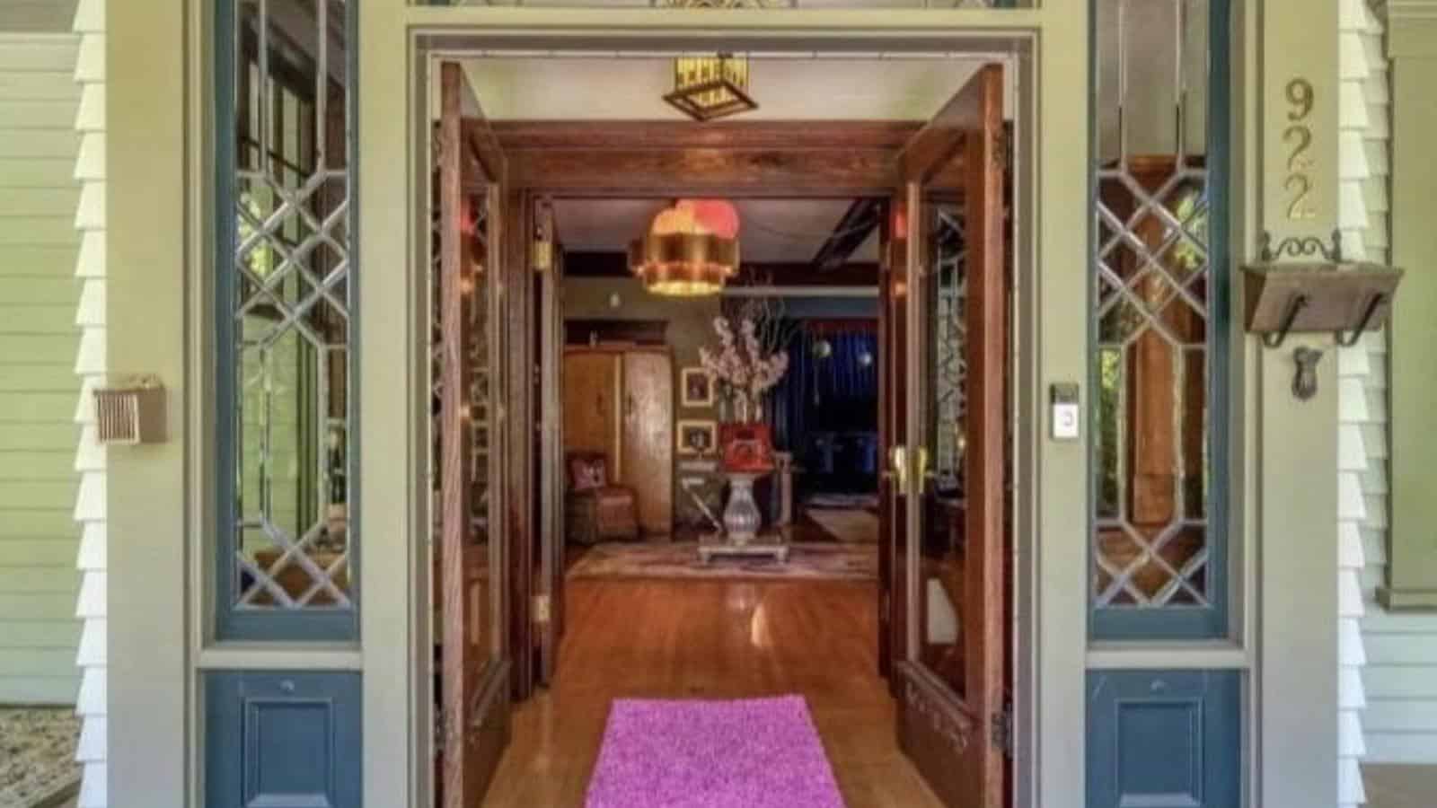 Close up view of front entrance of property with light green trim and open wooden doors