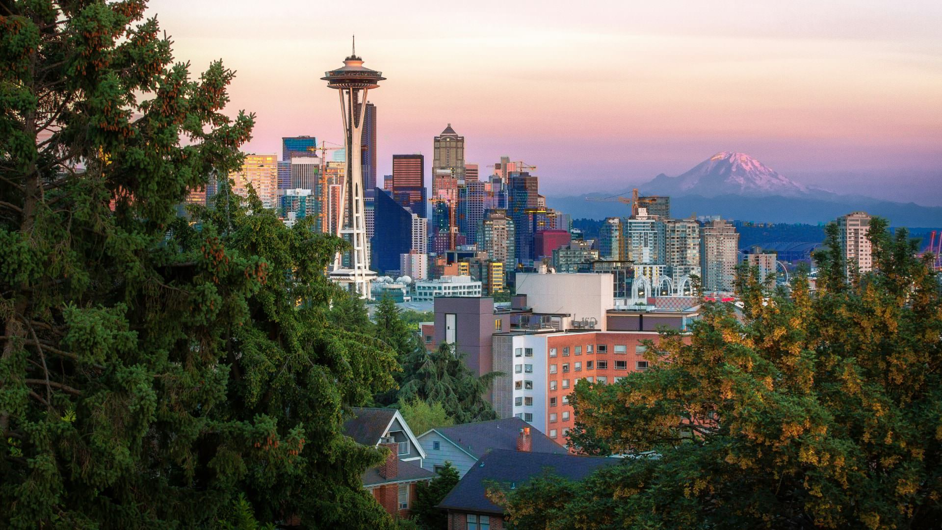 Downtown city view of Seattle with multiple buildings including the Space Needle with a mountain in the background